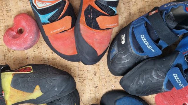 Scarpette da arrampicata di varie marche appoggiate su un tappeto di sughero